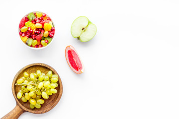 Healthy diet concept. Fruit salad near fresh fruits on white background top view copy space