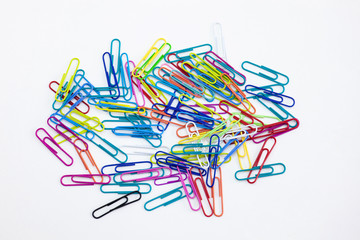 A group of colorful paper clips random stack on white background. Stationery office supplies concepts.