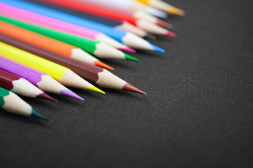Close-up colorful pencils, crayon with selective focus on brown color on glitter black background with copy space. Back to school concept, Drawing concept.
