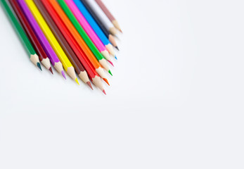 Creativity concept of art and drawing, Triangle shape of multi-colored crayon pencils isolated on white background with copy space. View from above, For banner poster design.