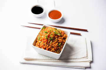Schezwan Fried Rice Masala is a popular indo-chinese food served in a plate or bowl with chopsticks. selective focus