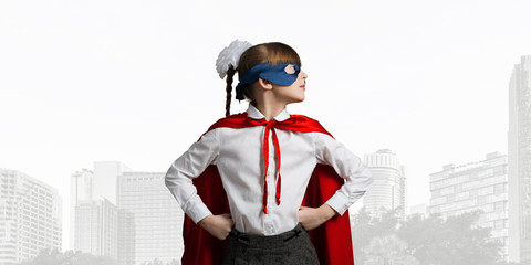 Girl power concept with cute kid guardian against cityscape background