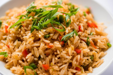 Schezwan Fried Rice Masala is a popular indo-chinese food served in a plate or bowl with chopsticks. selective focus