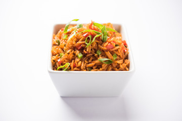 Schezwan Fried Rice Masala is a popular indo-chinese food served in a plate or bowl with chopsticks. selective focus