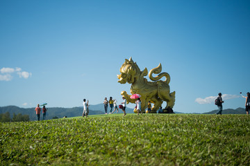 CHIANG RAI, THAILAND December 22, 2018 :Singha statue at Singha Park, Chiang Rai, Thailand. Tourists are taking pictures Gold Lion statue in Boon Rawd farm.