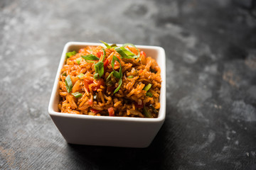 Schezwan Fried Rice Masala is a popular indo-chinese food served in a plate or bowl with chopsticks. selective focus