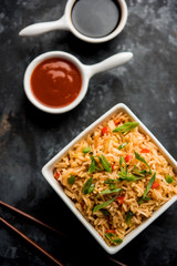 Schezwan Fried Rice Masala is a popular indo-chinese food served in a plate or bowl with chopsticks. selective focus