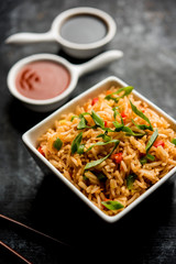 Schezwan Fried Rice Masala is a popular indo-chinese food served in a plate or bowl with chopsticks. selective focus