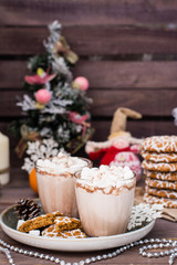 Hot cocoa with marshmallows and cinnamon in glasses on the table in Christmas decorations