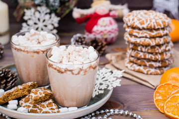 Hot cocoa with marshmallows and cinnamon in glasses on the table in Christmas decorations