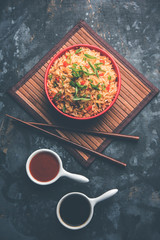 Schezwan Fried Rice Masala is a popular indo-chinese food served in a plate or bowl with chopsticks. selective focus