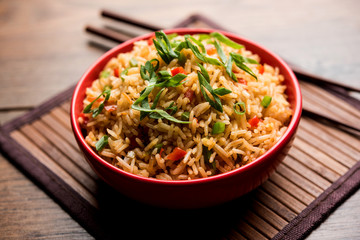 Schezwan Fried Rice Masala is a popular indo-chinese food served in a plate or bowl with chopsticks. selective focus