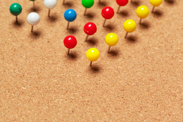 Group of thumbtacks pinned on corkboard in rows