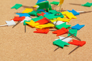 Mini flags thumbtacks over corkboard background close up