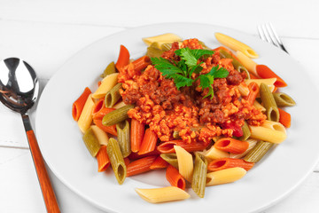 Pasta with meat, tomato sauce and vegetables on the table