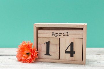 April 14th. Day 14 of april month, calendar on table with blue  background. Spring time