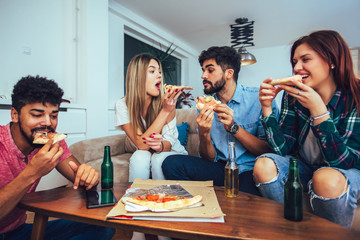 Group of young friends eating pizza.Home party.Fast food concept.