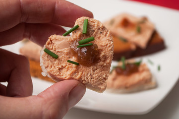 closeup of foie gras on bread in shaped heart in hand on festive table background © pixarno