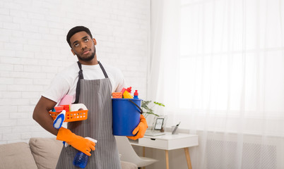 Black man boring of cleaning work at home