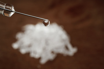Hard crystal drugs and prohibited substances, syringes, cooked heroine spoon on brown table. close up image on substances. Drug abuse and addiction concept. International Day against drug abuse