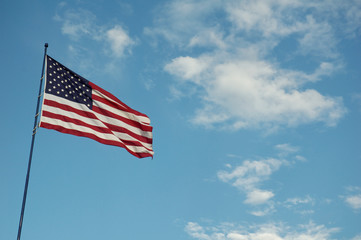 Americav flag with clouds and blue sky background