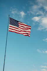 Americav flag with clouds and blue sky background