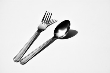 Cutlery set with fork and spoon isolated on pale white background