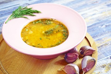 Delicious hot soup with rice, garlic and hot pepper on wooden background.