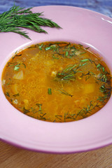 Delicious hot soup with rice, garlic and hot pepper on wooden background.