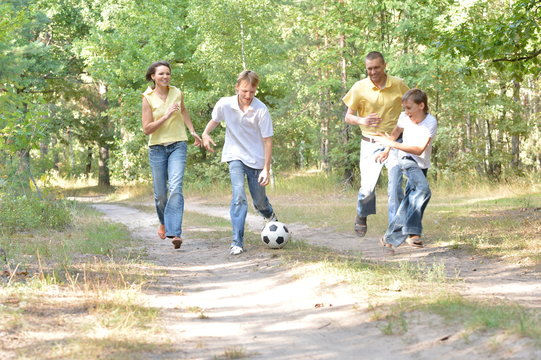 Portrait Of Happy Family Playing Soccer In Park