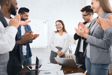 Business team congratulating successful female manager with applause