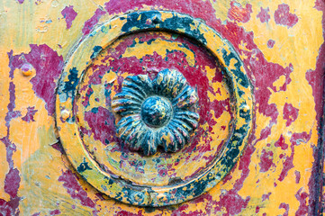 Cracked colorful paint on a metal ornament