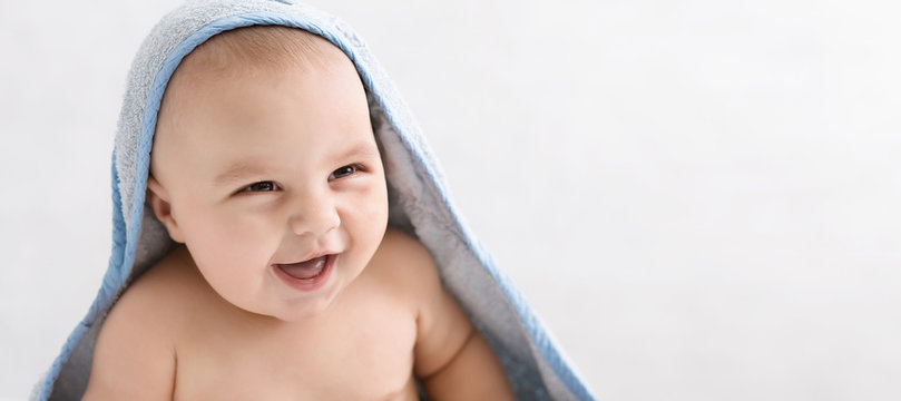 Cute little baby boy in hooded towel after bath
