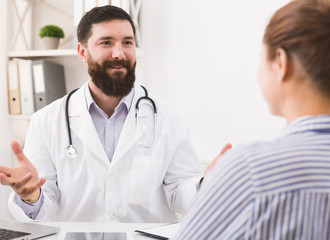 Smiling doctor talking to patient in office