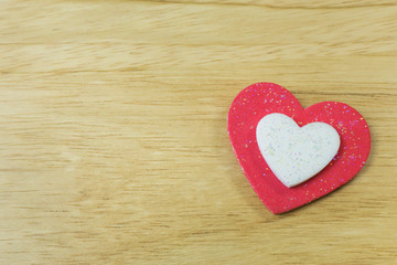 The red heart on wood background close up image.