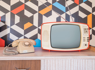 Retro television with vintage telephone and wallpaper in the background. Template interior...