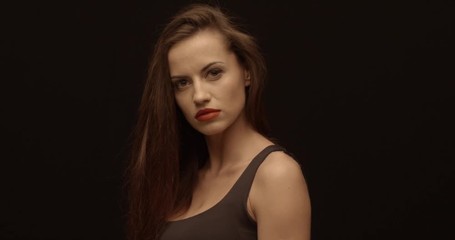 Bossy woman stands and looks into camera, red lips, female portrait