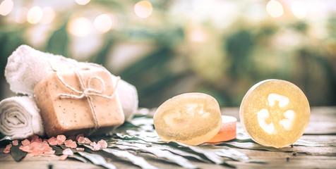 Spa handmade soap and a towel, the composition of the tropical leaves wooden background