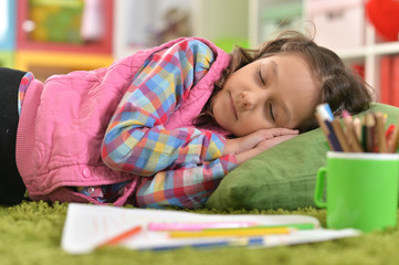 Portrait of cute girl sleeping on pillow on floor