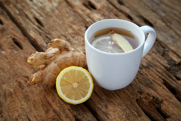 Cup of ginger tea with lemon on wooden