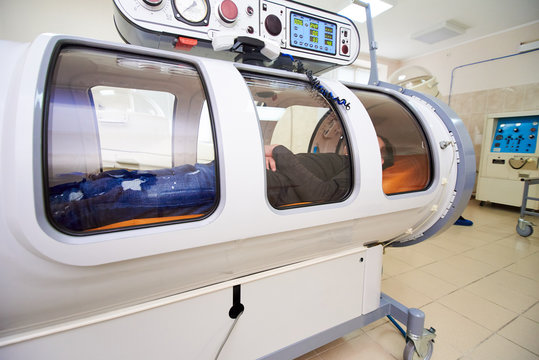 the guy in the black T-shirt lies in the hyperbaric chamber, oxygen therapy, medical room