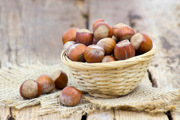 hazelnuts in a basket on old wooden background
