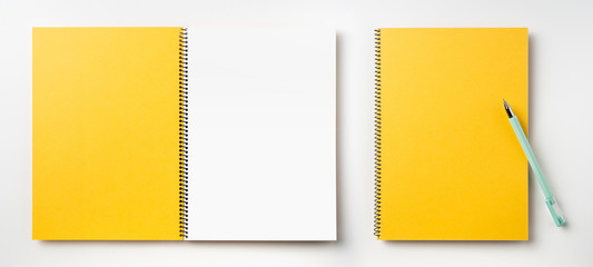 Top view of yellow spiral notebook, page, pencil