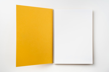 Top view of yellow spiral notebook with open page