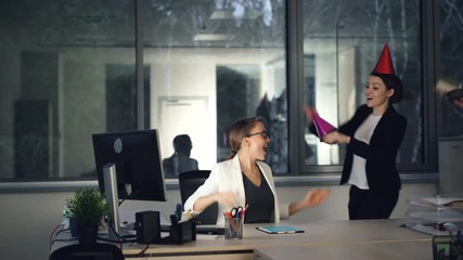 Pretty blonde is working in modern office when her colleagues are bringing birthday cake, present and party hats, girl is opening gift box and enjoying congratulations