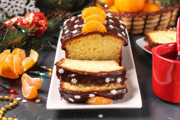 Cupcake with tangerines, covered with chocolate icing is located on the New Year's or Christmas background