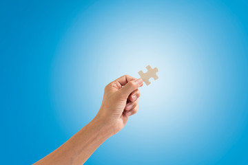 Hand holding jigsaw piece