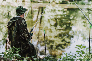 Rear view of a professional aged man using fishing equipment while enjoying active weekend