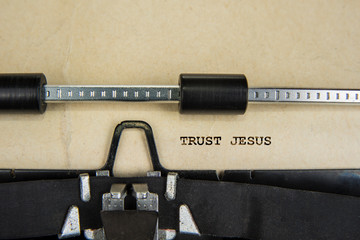 Spiritual sign trust jesus written on  an old typewriter