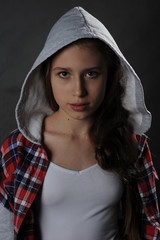 Beautiful teenager girl. Studio portrait. Dark background